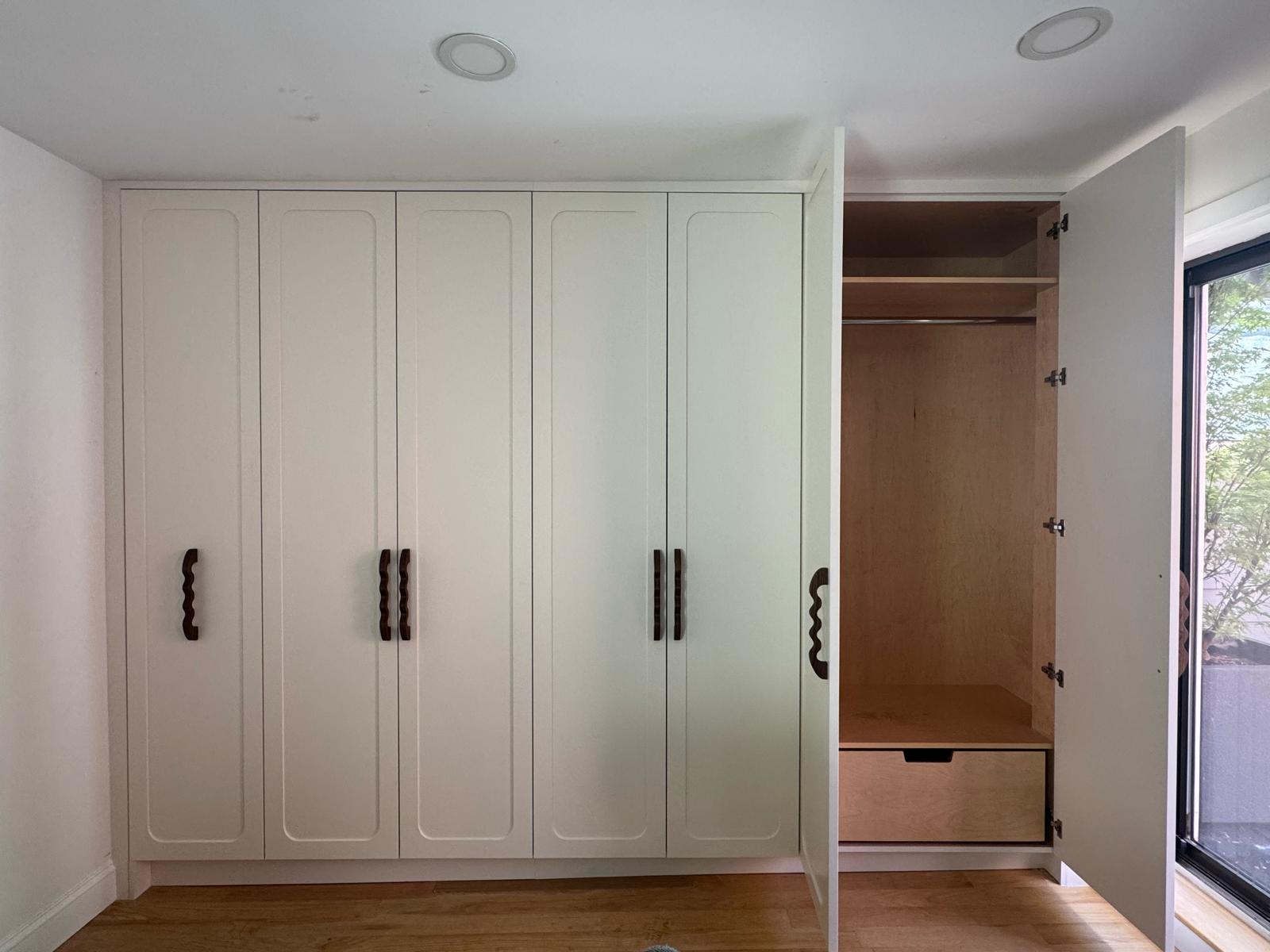 Finished built-in closet — closed view with walnut wavy handles